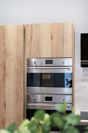 Eine Küche mit Einbauofen und Holzschrank.