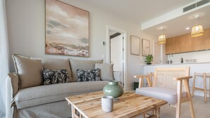 Ein modernes Wohnzimmer mit einer Couch, einem Couchtisch und einem Gemälde an der Wand.