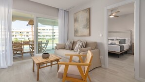Ein modernes Wohnzimmer mit einer Couch, einem Holztisch und einem Essbereich mit Stühlen.