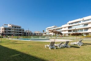 Ein Resort mit Pool, Liegestühlen und modernen Gebäuden.