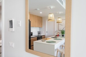 A modern kitchen with a central island, wooden cabinets, and pendant lighting. - Los Colibríes by H - Isla Canela Golf GLHC7012P102 (Ayamonte)