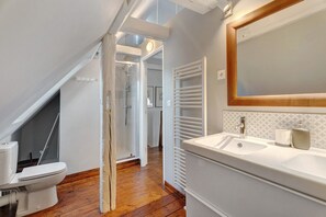 A bathroom with a white sink, a mirror, and a shower. - Apartment 'Lucia - Duplex Climatisé' with Mountain View, Wi-Fi and Air Conditioning (Obernai)