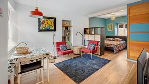 Un dormitorio moderno con cama, escritorio, silla y estantería.