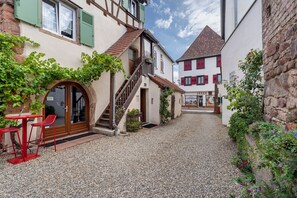 A courtyard with a gravel path, a staircase, and a building with a door and windows. - Studio "Casa Lucia - Air Conditioning" with Wi-Fi and Air Conditioning (Obernai)