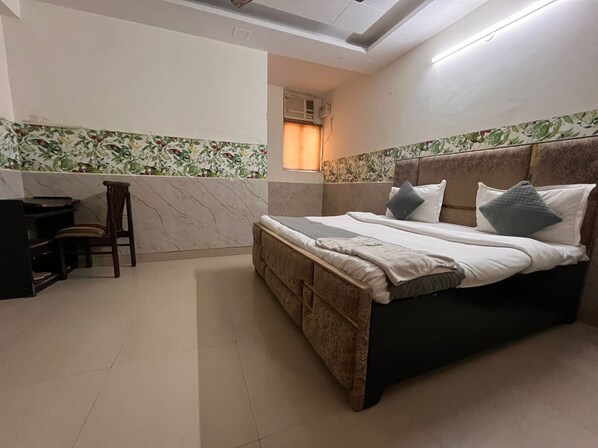 A bedroom with a bed, a desk, and a chair. - Smart Stay Malviya Nagar (New Delhi)