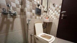 Un baño con inodoro, ducha y lavabo.