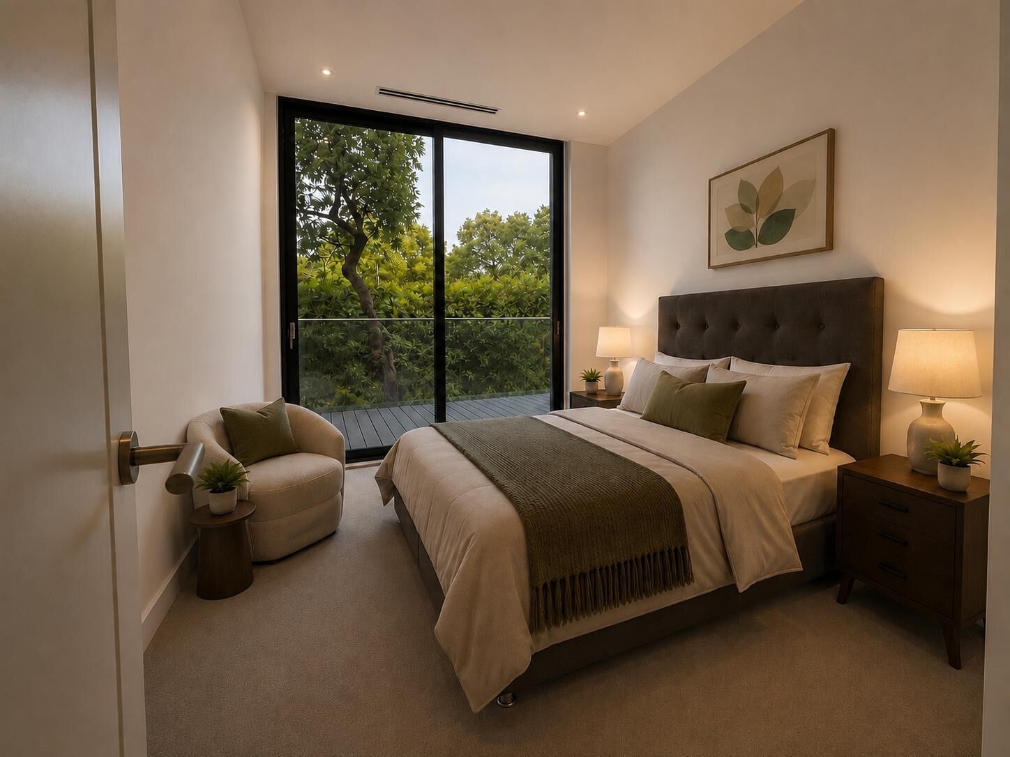 A modern bedroom with a large bed, a chair, a nightstand, and a view of greenery through a sliding door.
