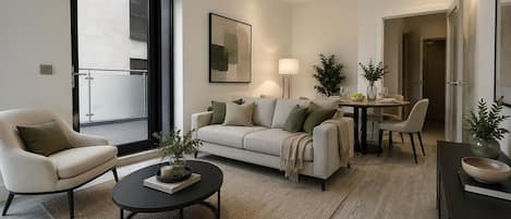 Un salon moderne comprenant un canapé, un fauteuil, une table basse et un coin repas.