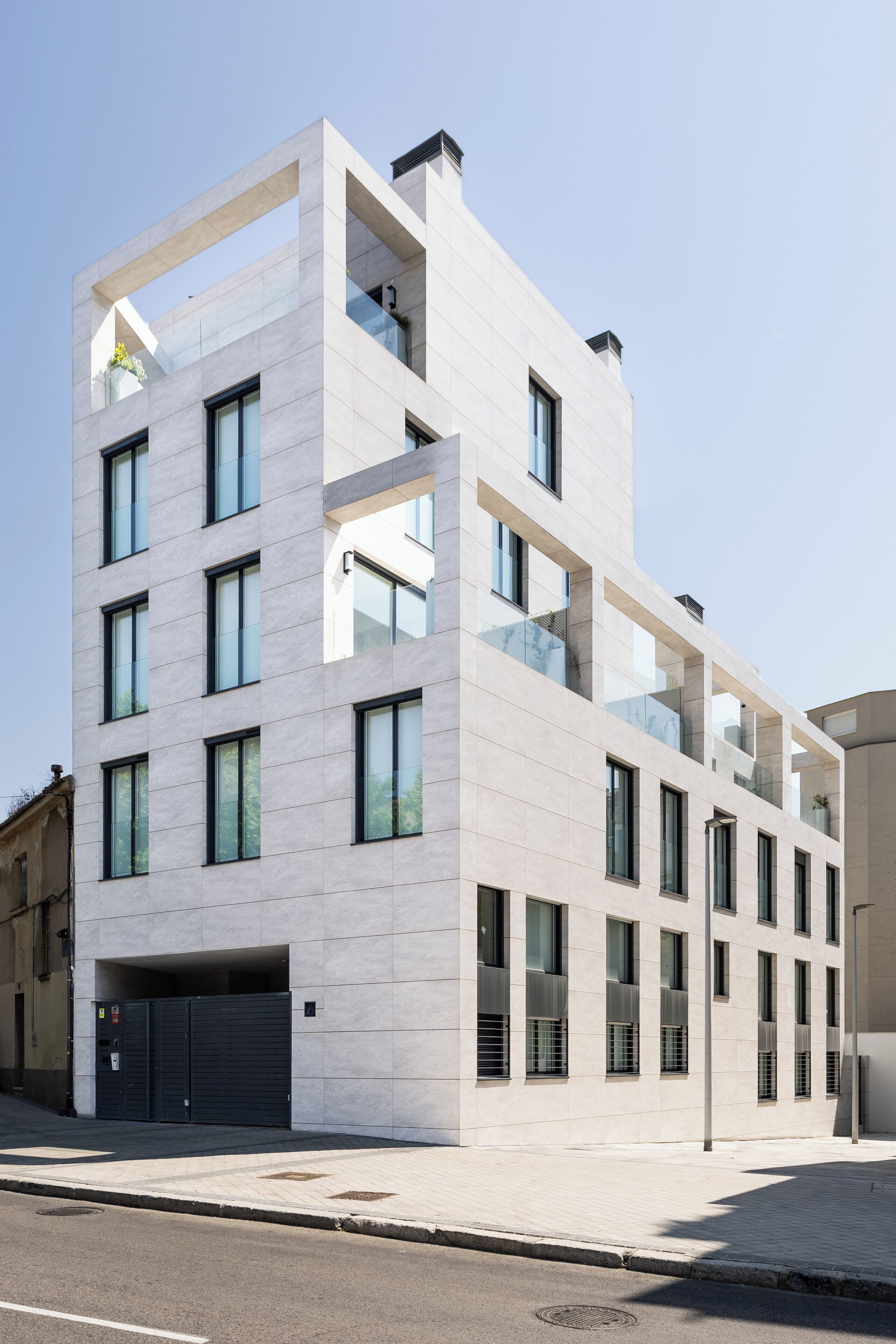 Un immeuble moderne à plusieurs étages, doté de grandes fenêtres et d’une façade plane.