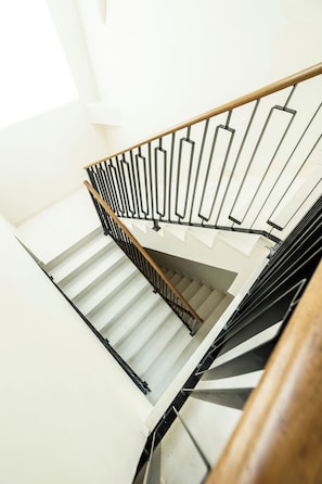 A staircase with a wooden handrail and metal balusters.