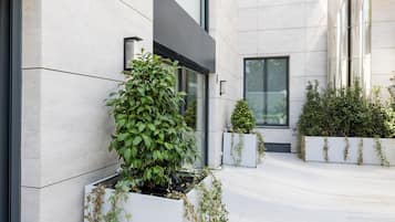 Um edifício moderno com um pátio, apresentando grandes janelas e um design limpo e geométrico.