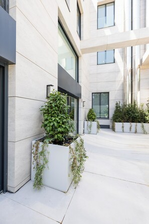 A modern building with a courtyard, featuring large windows and a clean, geometric design.