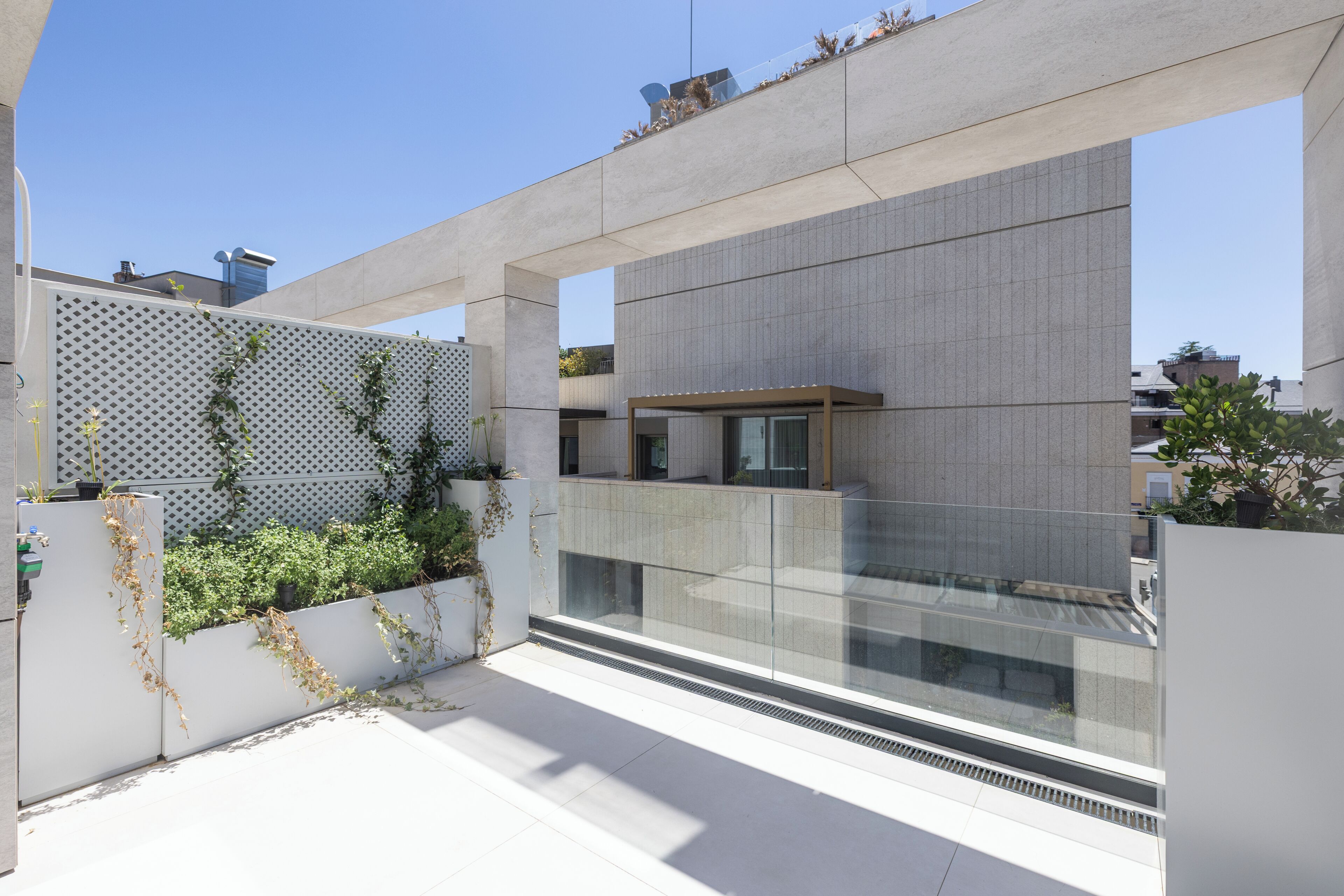 Un edificio moderno con fachada de vidrio, techo plano y pared exterior blanca.