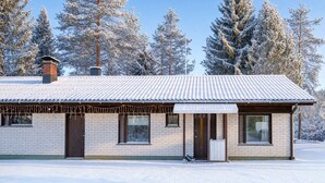 A two-story building with a tiled roof, brick walls, and a chimney. - Teddy`s Hideout, Private Sauna By Lapland Host (Rovaniemi)