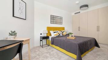 Ein modernes Schlafzimmer mit Bett, Nachttisch, Lampe und großem Kleiderschrank.