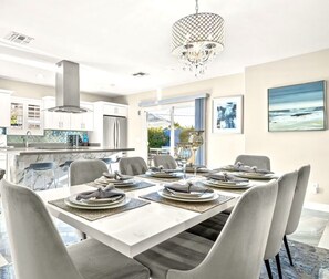 A modern dining area with a large table set for six, a chandelier, and a view of the outdoors. - Contemporary Resort Home w/ Heated Pool, Old Town (Scottsdale)