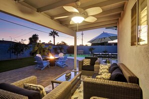 An outdoor patio with wicker furniture, a ceiling fan, and a view of the backyard. - Contemporary Resort Home w/ Heated Pool, Old Town (Scottsdale)