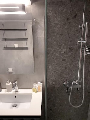 Ein Badezimmer mit Waschbecken, Spiegel und Dusche.