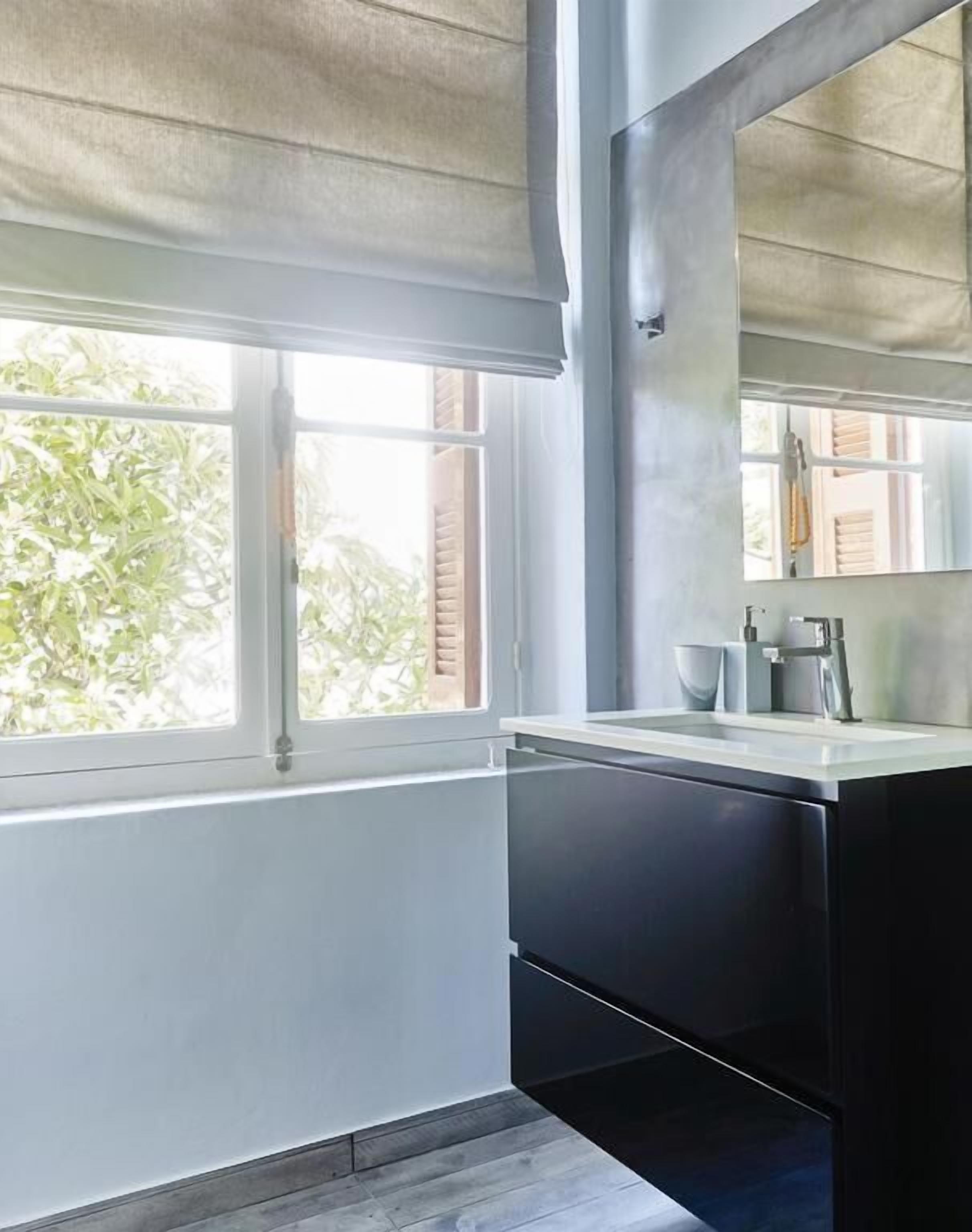 Una cocina moderna con ventana, un lavabo y un espejo.