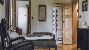 Un dormitorio con cama, armario de madera, cómoda y espejo.