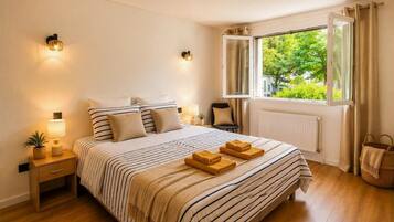 Une chambre d’hôtel avec un lit, des lampes de chevet, une fenêtre avec des rideaux, un radiateur et un plancher en bois.