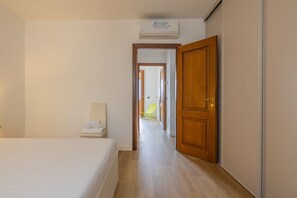A hotel room with a bed, a chair, a wardrobe, and an air conditioning unit. - Viandante Lake View by Varenna Holidays (Bellano)