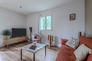 A living room with a television, a sofa, a coffee table, and a cactus. - Holiday Home 'Mazet Avec Terrasse Et Clim' with Private Terrace, Wi-Fi and Air Conditioning (Courthézon)