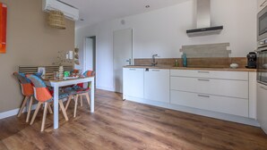 Eine moderne Küche mit weißen Schränken, einer Holz Arbeitsplatte und einem eingebauten Backofen.