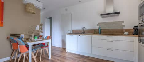 Eine moderne Küche mit weißen Schränken, einer Holz Arbeitsplatte und einem eingebauten Backofen.