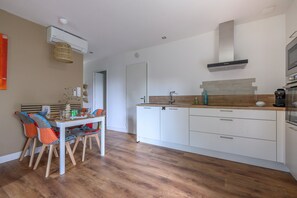 A modern kitchen with white cabinetry, a wooden countertop, and a built-in oven. - Holiday Home 'Mazet Avec Terrasse Et Clim' with Private Terrace, Wi-Fi and Air Conditioning (Courthézon)
