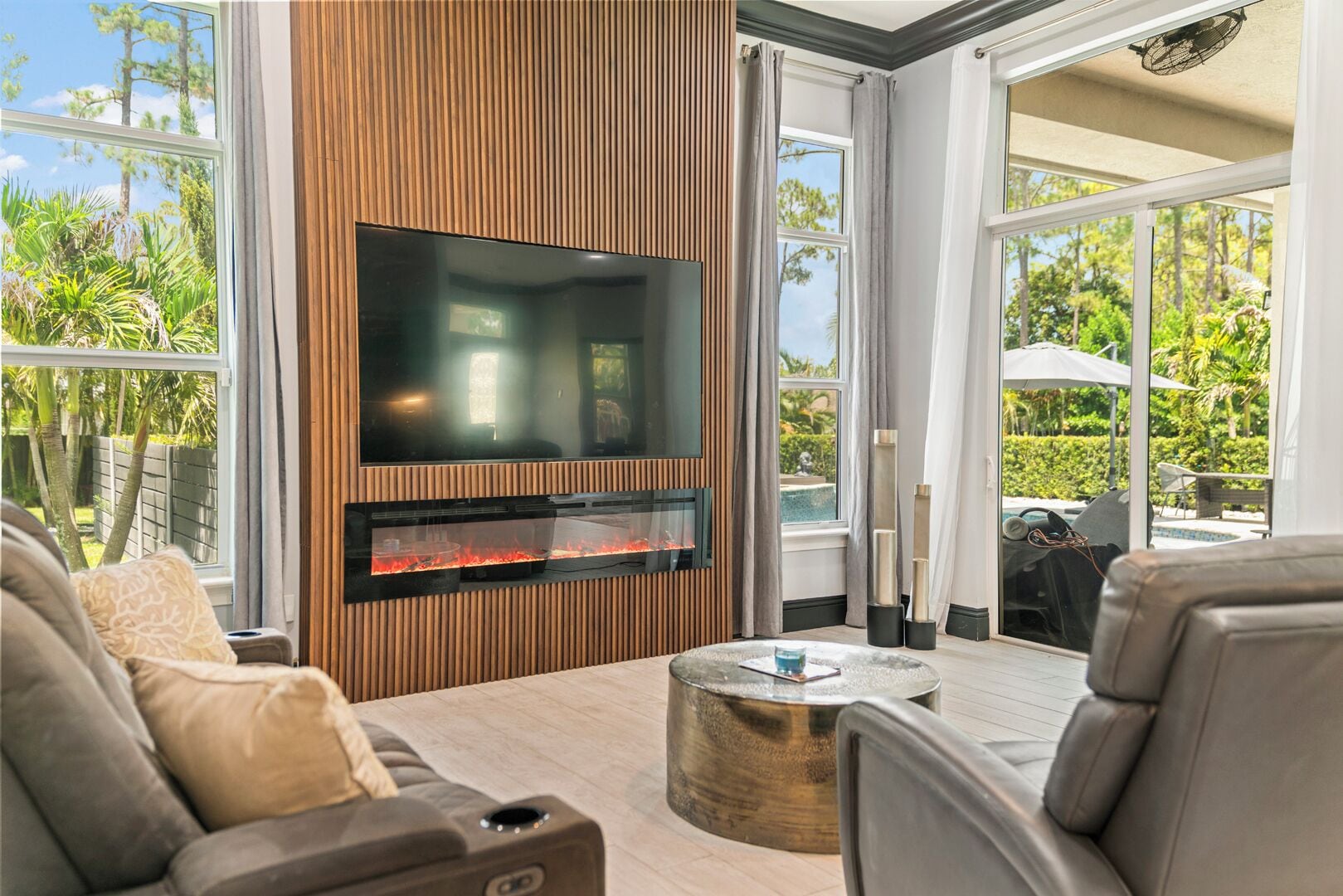 Una sala de estar moderna con un televisor de pantalla plana, una chimenea empotrada y un espacio de descanso acogedor.