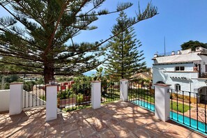 A rooftop terrace with a swimming pool, potted plants, and a view of a white building. - Hacienda Clavero Ten Pool Apartment (Málaga)