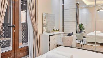 Une chambre d’hôtel moderne avec un grand lit, un bureau avec une chaise, un miroir et une armoire.