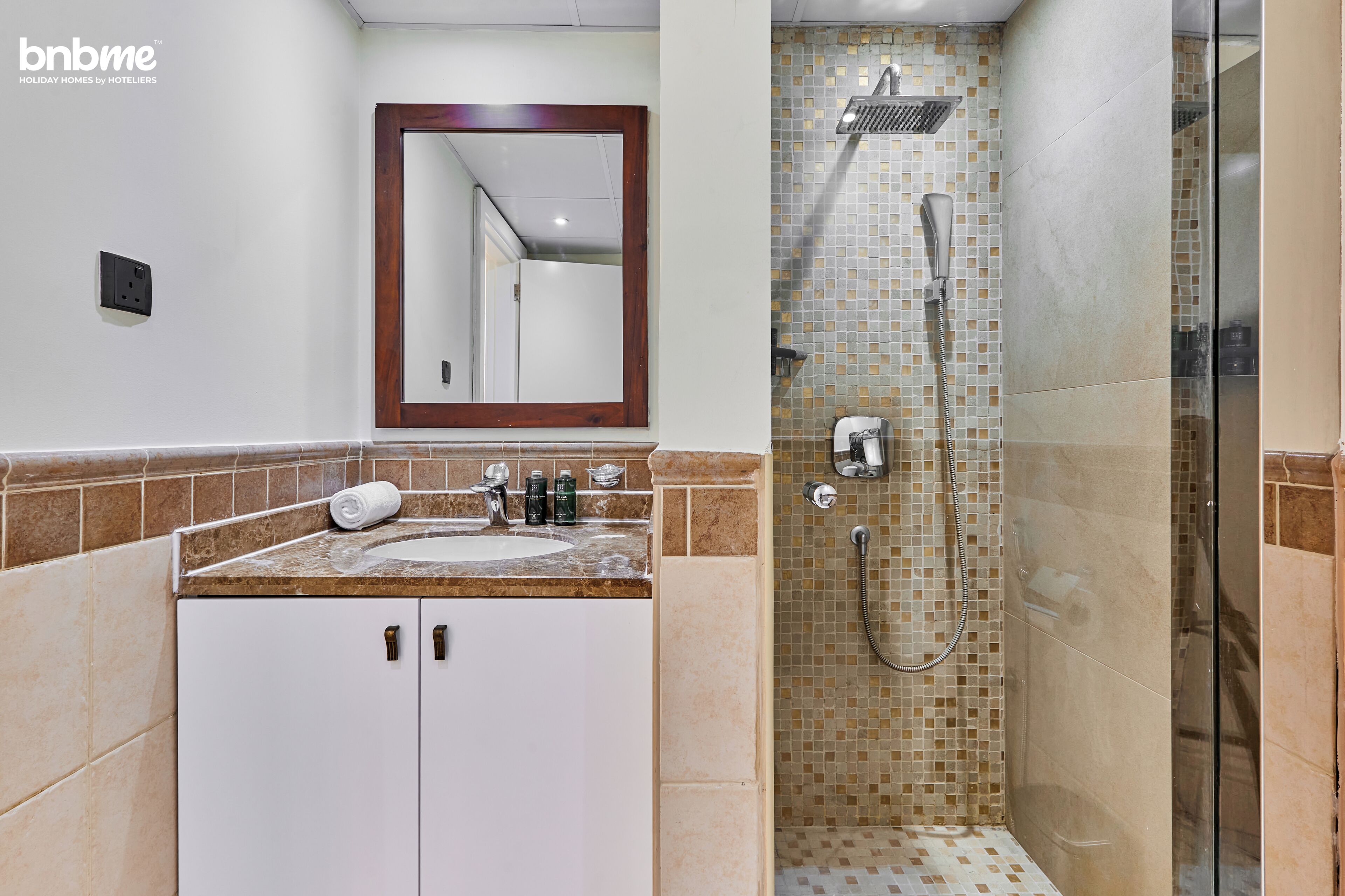Une salle de bain avec un lavabo, un miroir et une douche.