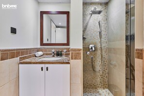 Ein Badezimmer mit Waschbecken, Spiegel und Dusche.