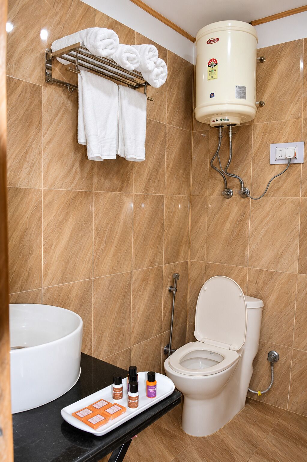 Un baño con inodoro, lavamanos y toallero.