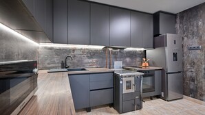 A modern kitchen with dark cabinetry, stainless steel appliances, and a wooden countertop. - Holiday Home Cerine Hill by Villas Guide (Gornji Vinkovec)
