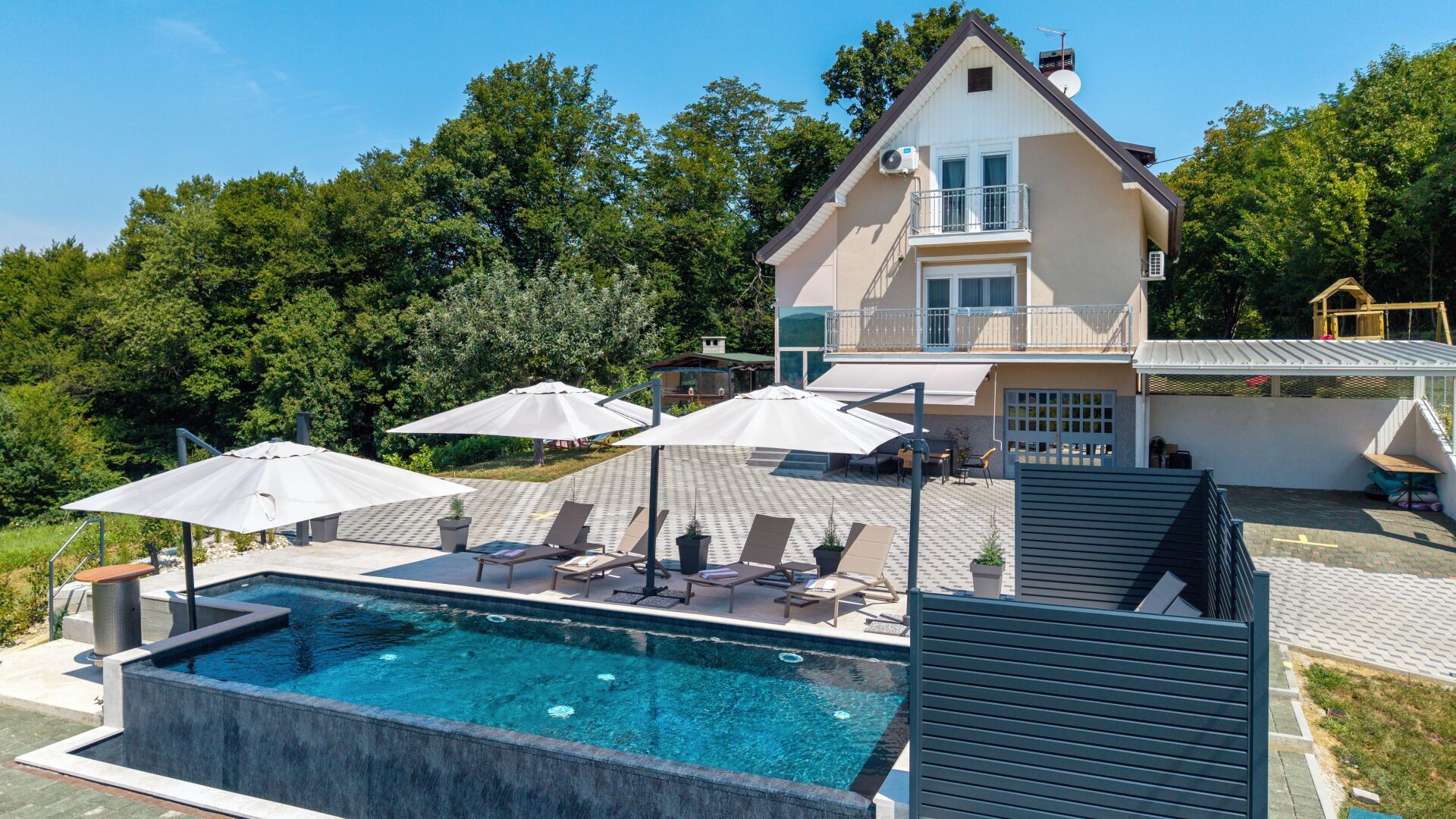 Une maison à deux étages dotée d’une piscine, d’un espace salon extérieur et d’un patio couvert.