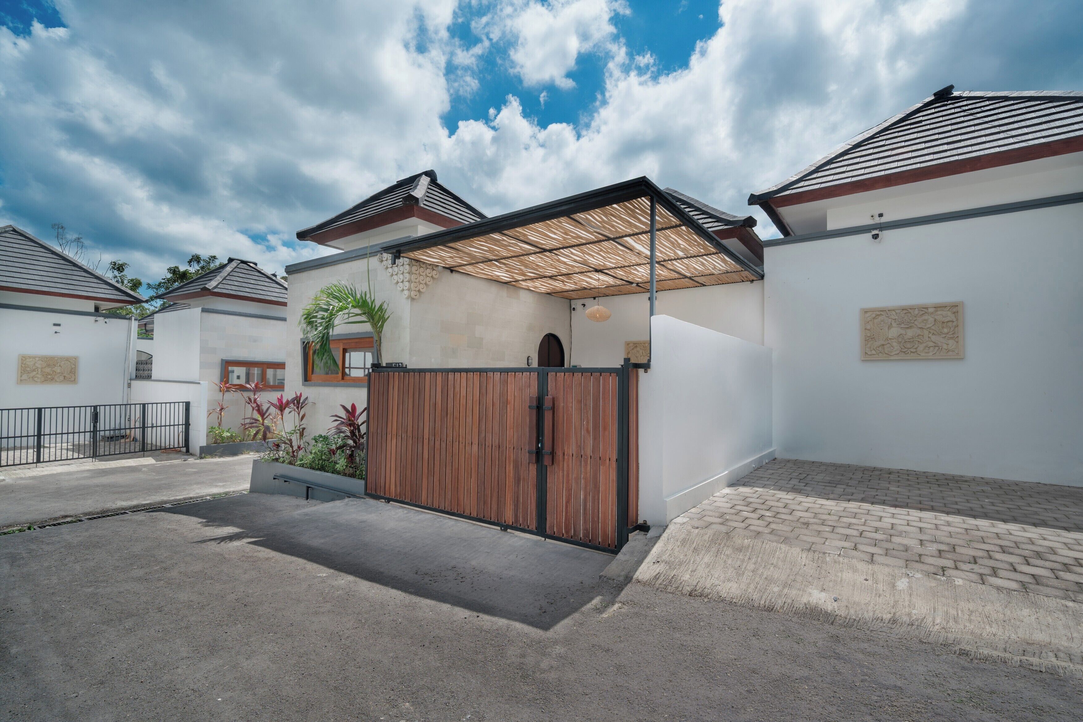 A residential property with a gated entrance, a covered patio, and a brick pathway.