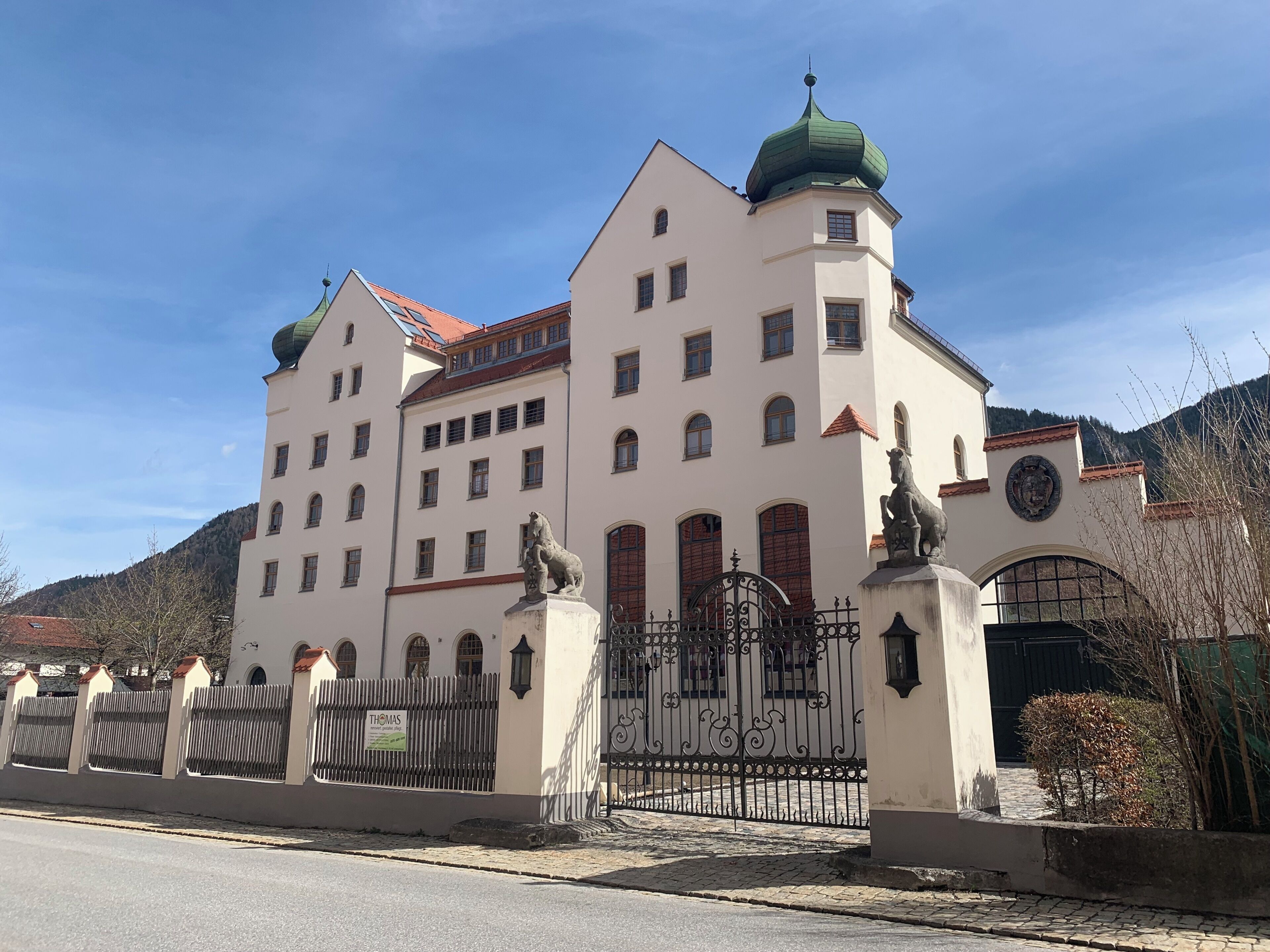 Ein großes, historisches Gebäude mit zahlreichen Fenstern und einer markanten, grünen Kuppel.
