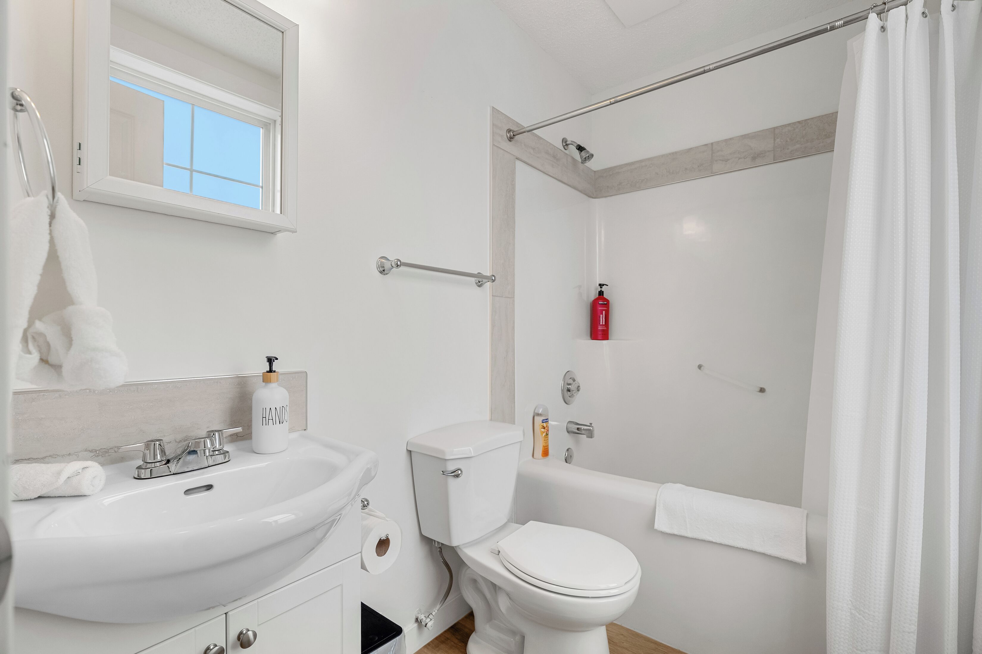 A bathroom with a sink, toilet, and bathtub.