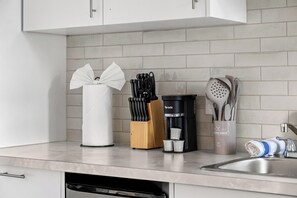 A kitchen with a coffee maker, knife block, and utensils. - Edmonton Convention Centre Studio | Parking, Wifi (Edmonton)