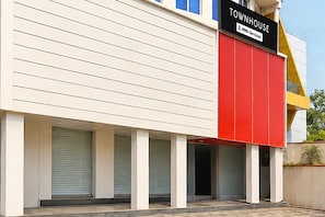 A building with a sign reading 'TOWNHOUSE' and 'Oyo-Serviced.' There are closed shutters on the ground floor. - Deluxe Hotel Sunbeam (Gwalior)