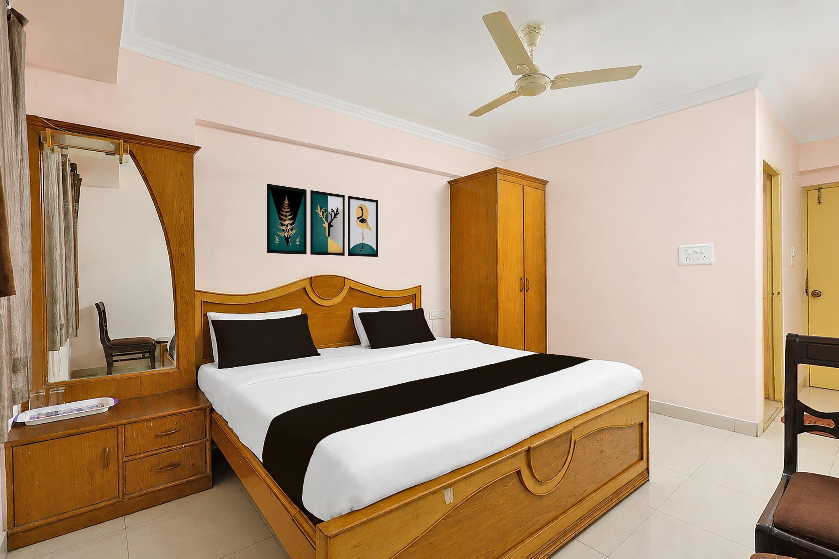 A bedroom with a wooden bed, a nightstand, a mirror, a wardrobe, and a ceiling fan.