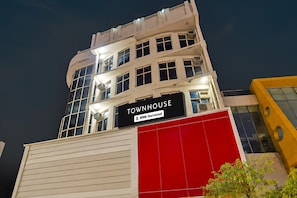 Un edificio de varios pisos con un letrero que dice 'TOWNHOUSE' y 'OYO-Serviced'.