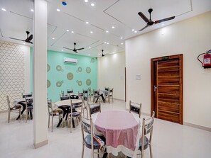 A conference room with tables, chairs, ceiling fans, and an air conditioning unit.