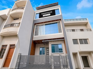A multi-story building with a sign indicating it is serviced by OYO.
