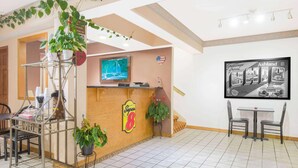 A reception area with a wooden counter, a television, and a wall-mounted sign.