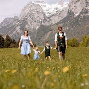 A family walking in a field with mountains in the background. - "In de Berg" Vacation Rental, 1–2 people, shower/toilet, Wi-Fi (Ramsau bei Berchtesgaden)