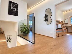 A modern interior with a staircase, a potted plant, and artwork on the walls.